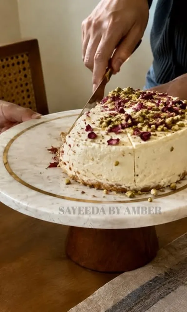Marble and wood cake stand holding a pistachio cake
