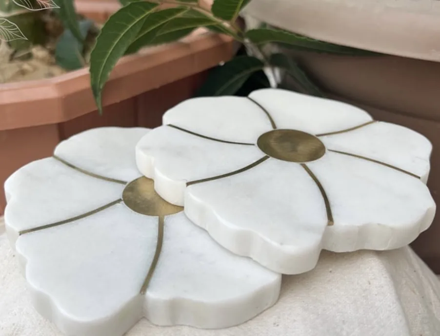 Phool marble coasters shaped as petals with brass centres